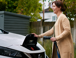 womamn charging an electric car